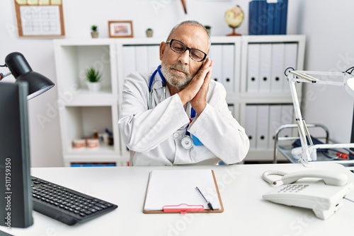 Wallpaper Mural Mature doctor man at the clinic sleeping tired dreaming and posing with hands together while smiling with closed eyes. Torontodigital.ca