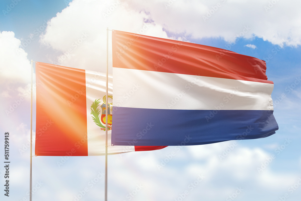 Sunny blue sky and flags of netherlands and peru Sunny blue sky and flags of netherlands and peru
