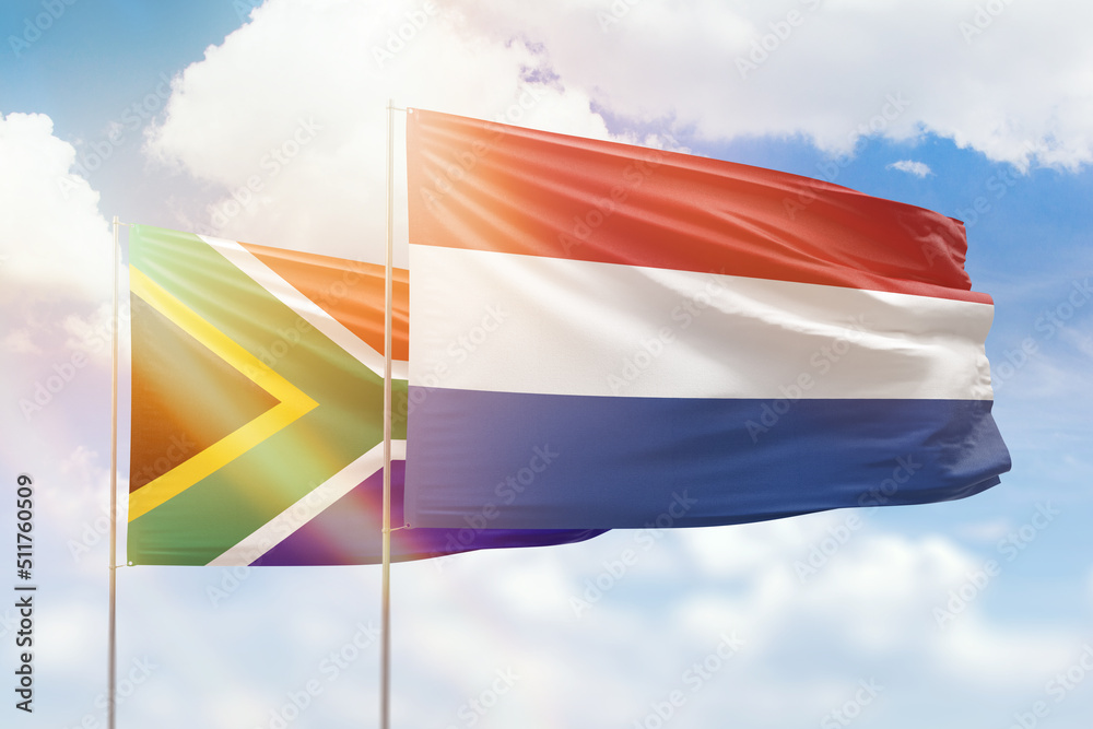 Sunny blue sky and flags of netherlands and south africa Sunny blue sky and flags of netherlands and south africa