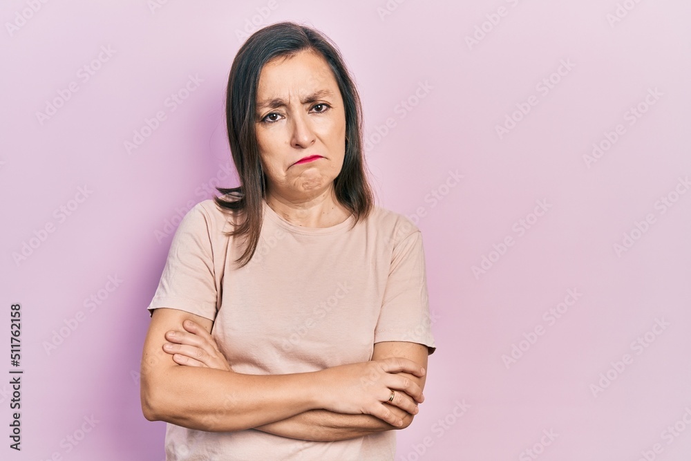 Middle age hispanic woman with arms crossed gesture depressed and worry for distress, crying angry and afraid. sad expression. Middle age hispanic woman with arms crossed gesture depressed and worry for distress, crying angry and afraid. sad expression.