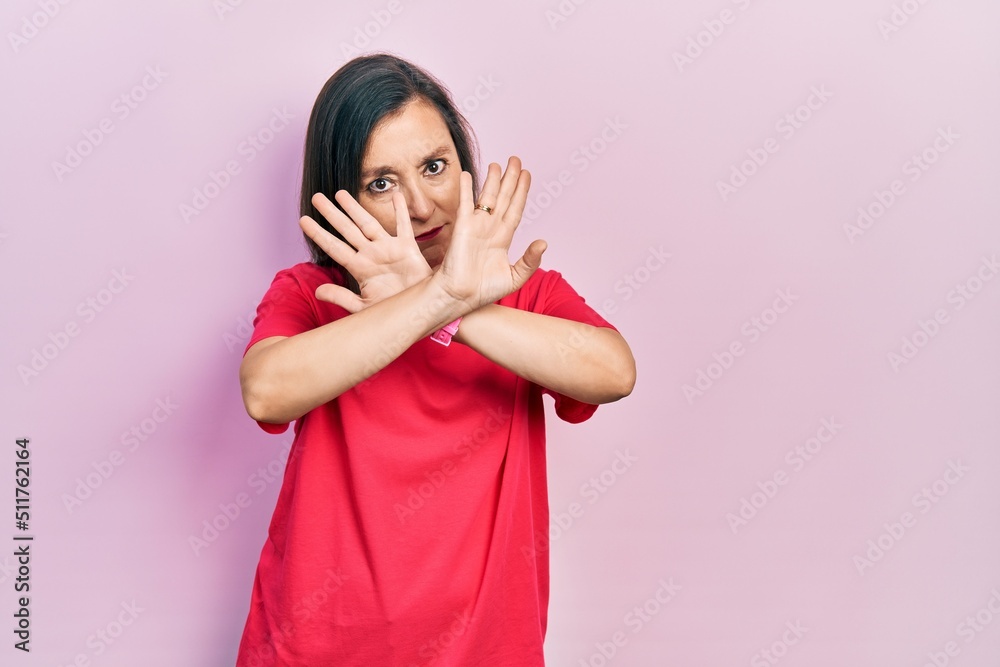 Middle age hispanic woman wearing casual clothes rejection expression crossing arms doing negative sign, angry face Middle age hispanic woman wearing casual clothes rejection expression crossing arms doing negative sign, angry face