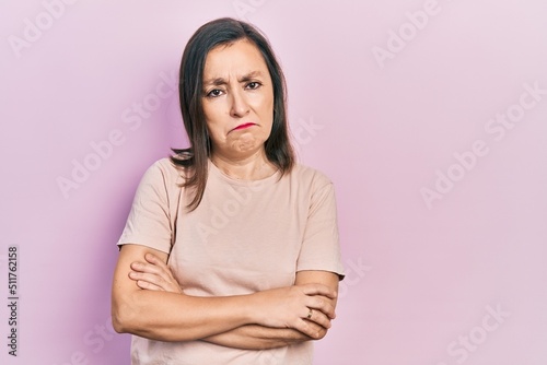 Middle age hispanic woman with arms crossed gesture depressed and worry for distress, crying angry and afraid. sad expression.