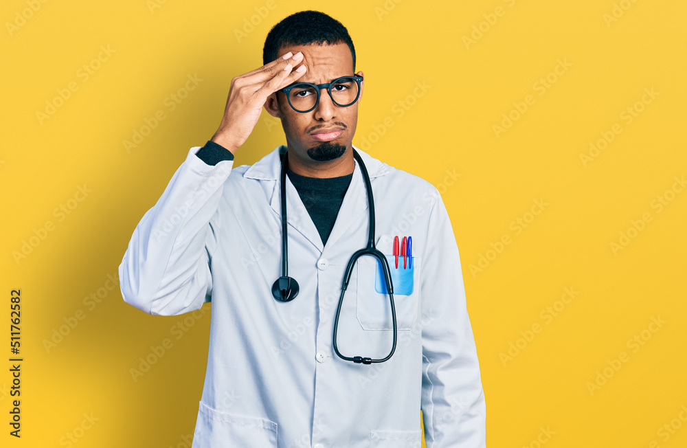 Young african american man wearing doctor uniform and stethoscope worried and stressed about a problem with hand on forehead, nervous and anxious for crisis Young african american man wearing doctor uniform and stethoscope worried and stressed about a problem with hand on forehead, nervous and anxious for crisis