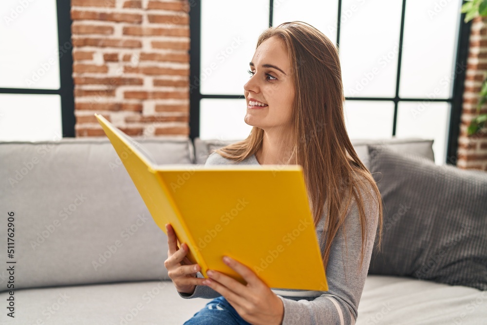 Young blonde woman smiling confident reading book at home