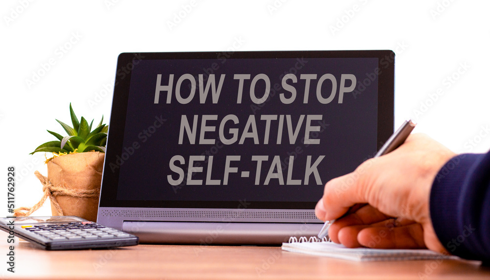 Stop negative self-talk symbol. Concept words How to stop negative self-talk on the black tablet. Businessman hand with pen. Psychological and stop negative self-talk concept. Copy space. Stop negative self-talk symbol. Concept words How to stop negative self-talk on the black tablet. Businessman hand with pen. Psychological and stop negative self-talk concept. Copy space.