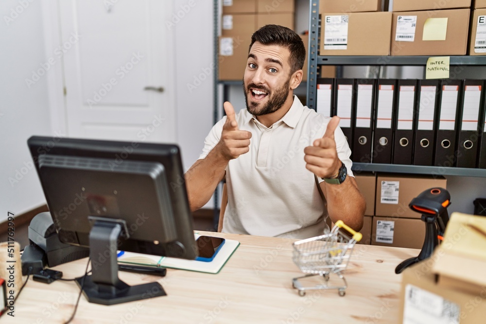 Handsome hispanic man working at small business commerce pointing fingers to camera with happy and funny face. good energy and vibes. Handsome hispanic man working at small business commerce pointing fingers to camera with happy and funny face. good energy and vibes.