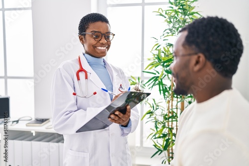 Man and woman doctor and patient having medical consultation speaking at clinic photo