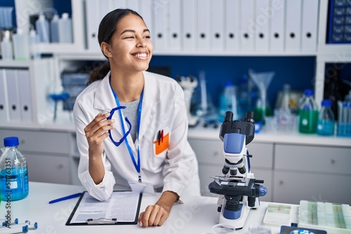 Young african american woman scientist smiling confident at laboratory