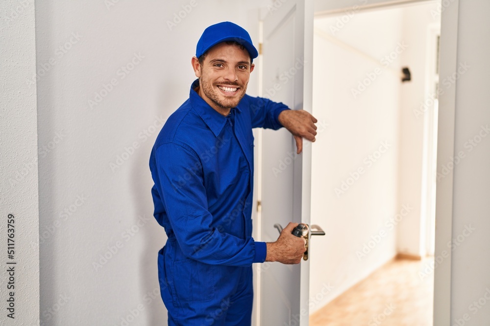 Young hispanic man technician repairing door at home Young hispanic man technician repairing door at home