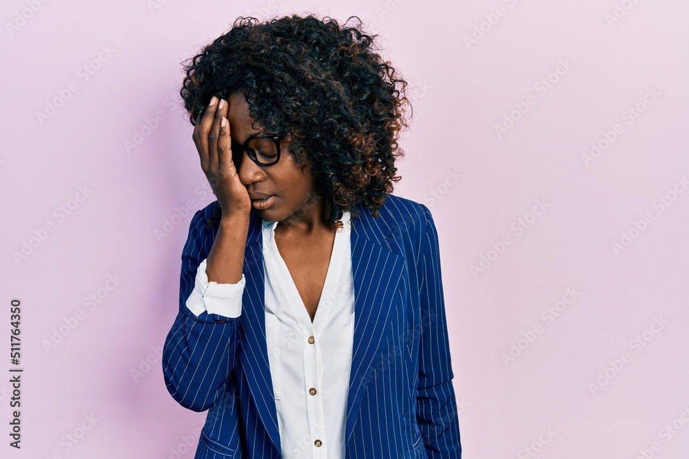 Young african american woman wearing business clothes and glasses yawning tired covering half face, eye and mouth with hand. face hurts in pain.