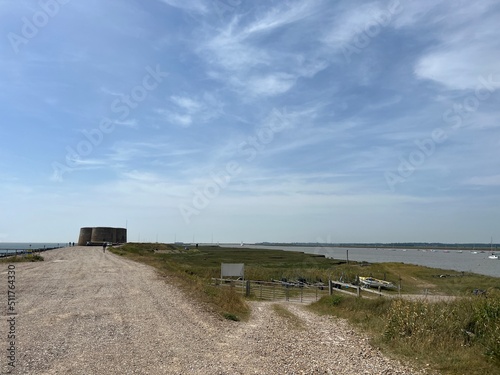  Landscape with Martello tower historic stone forts built as 19th century sea defences on East Anglia coastline Aldeburgh beach Suffolk uk with wooden bridge over moat in Summer blue skies  © Carmina