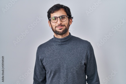 Handsome latin man standing over isolated background puffing cheeks with funny face. mouth inflated with air, crazy expression. © Krakenimages.com