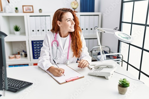 Young redhead woman wearing doctor uniform working at hospital