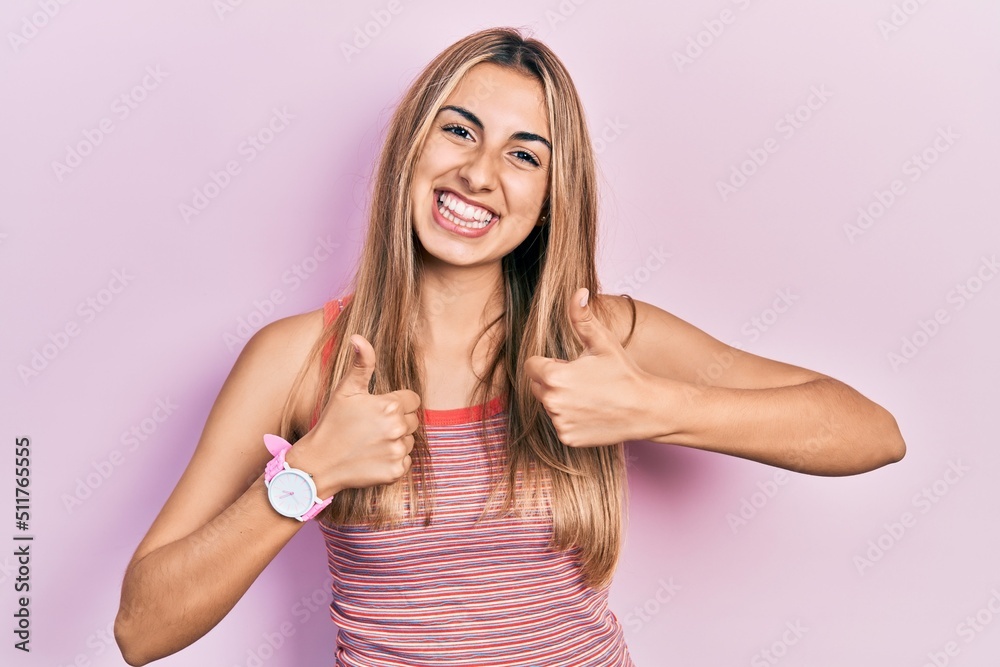 Beautiful hispanic woman wearing casual summer t shirt success sign doing positive gesture with hand, thumbs up smiling and happy. cheerful expression and winner gesture. Beautiful hispanic woman wearing casual summer t shirt success sign doing positive gesture with hand, thumbs up smiling and happy. cheerful expression and winner gesture.