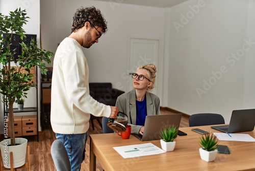 Businessman pouring coffee to his worker partner at the office