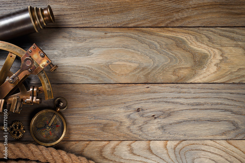 Vintage compass, sextant, ropes and spyglass on shipboard oak boards. photo