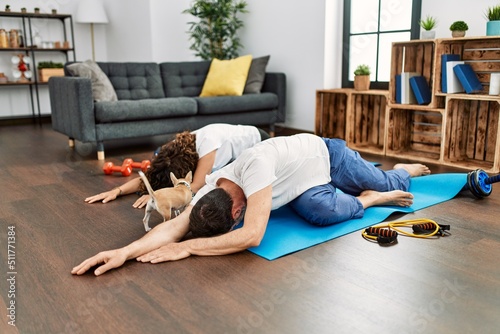 Wallpaper Mural Middle age hispanic couple smiling happy stretching on the floor at home. Torontodigital.ca