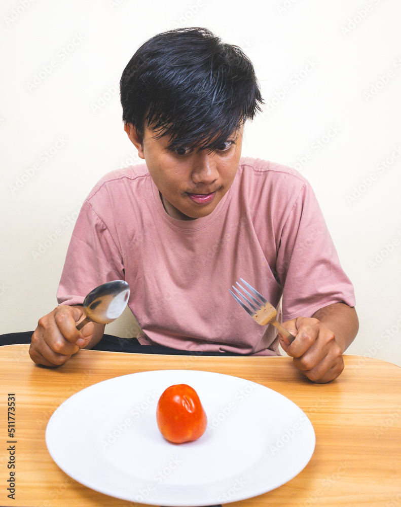 Sad hungry man eating vegetables isolated on white background