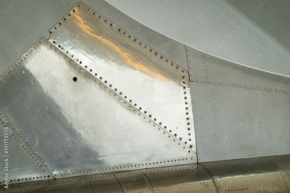 Close up on metal panels on the fuselage of an aircraft near tail section. Suitable for background for graphics and text