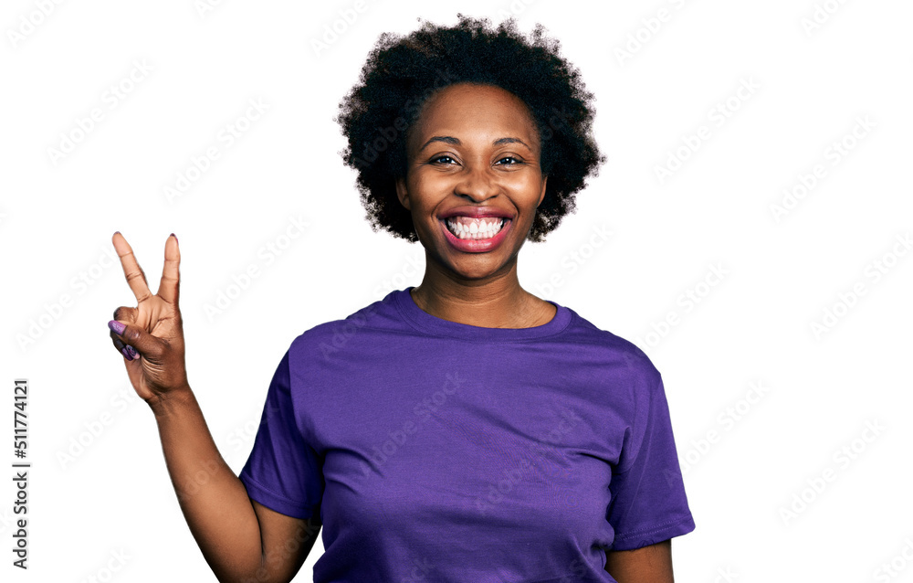 African american woman with afro hair wearing casual purple t shirt showing and pointing up with fingers number two while smiling confident and happy. African american woman with afro hair wearing casual purple t shirt showing and pointing up with fingers number two while smiling confident and happy.