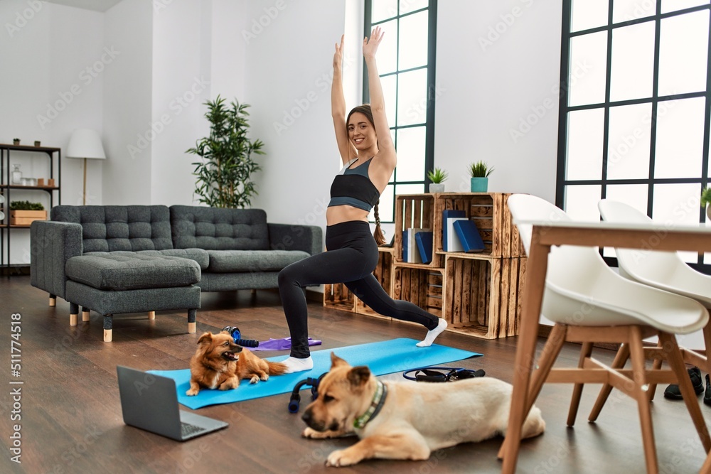 © Krakenimages.com - Young hispanic woman smiling confident having online yoga class at home