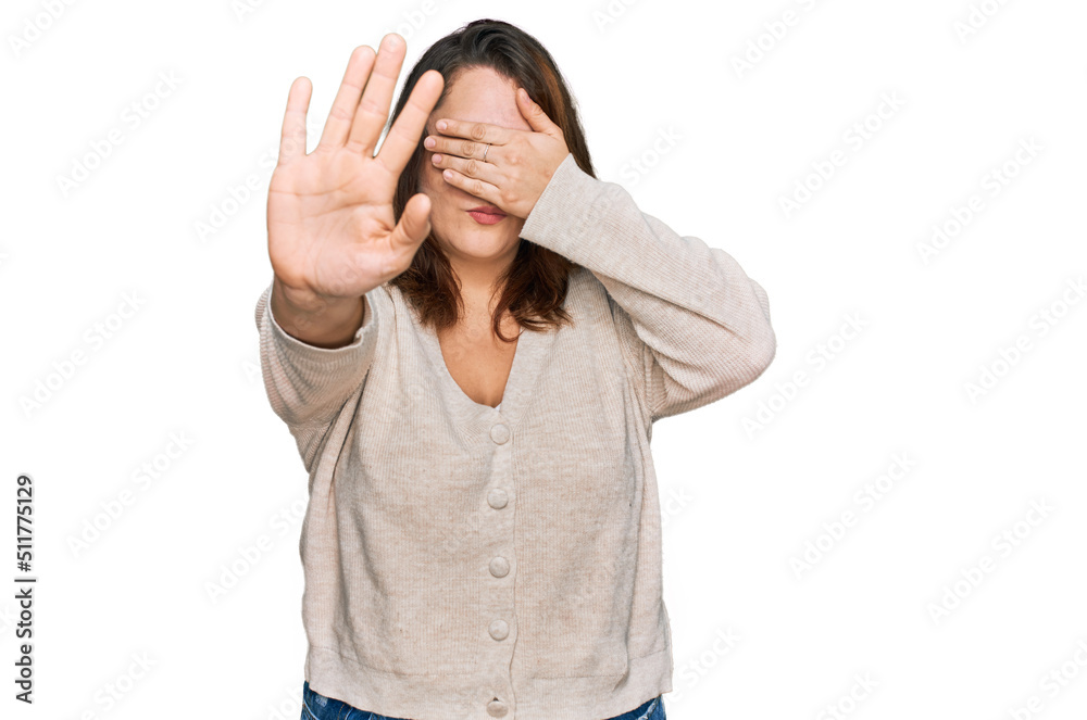 Young plus size woman wearing casual clothes covering eyes with hands and doing stop gesture with sad and fear expression. embarrassed and negative concept. Young plus size woman wearing casual clothes covering eyes with hands and doing stop gesture with sad and fear expression. embarrassed and negative concept.