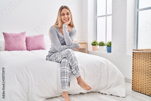 Young woman smiling confident sitting on bed at bedroom
