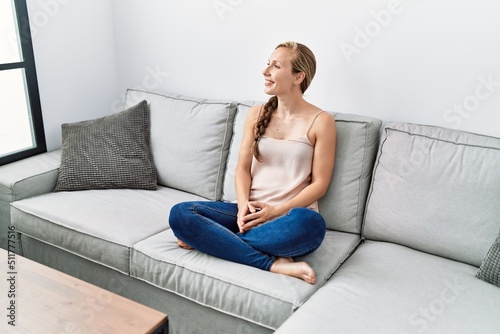 Young caucasian woman smiling confident sitting on sofa at home