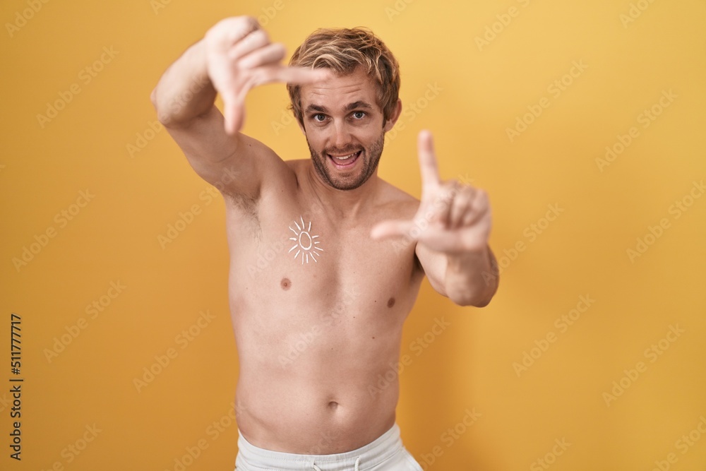 Caucasian man standing shirtless wearing sun screen smiling making frame with hands and fingers with happy face. creativity and photography concept. Caucasian man standing shirtless wearing sun screen smiling making frame with hands and fingers with happy face. creativity and photography concept.