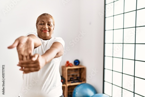 Senior african american woman smiling confident training using grip hand at sport center photo