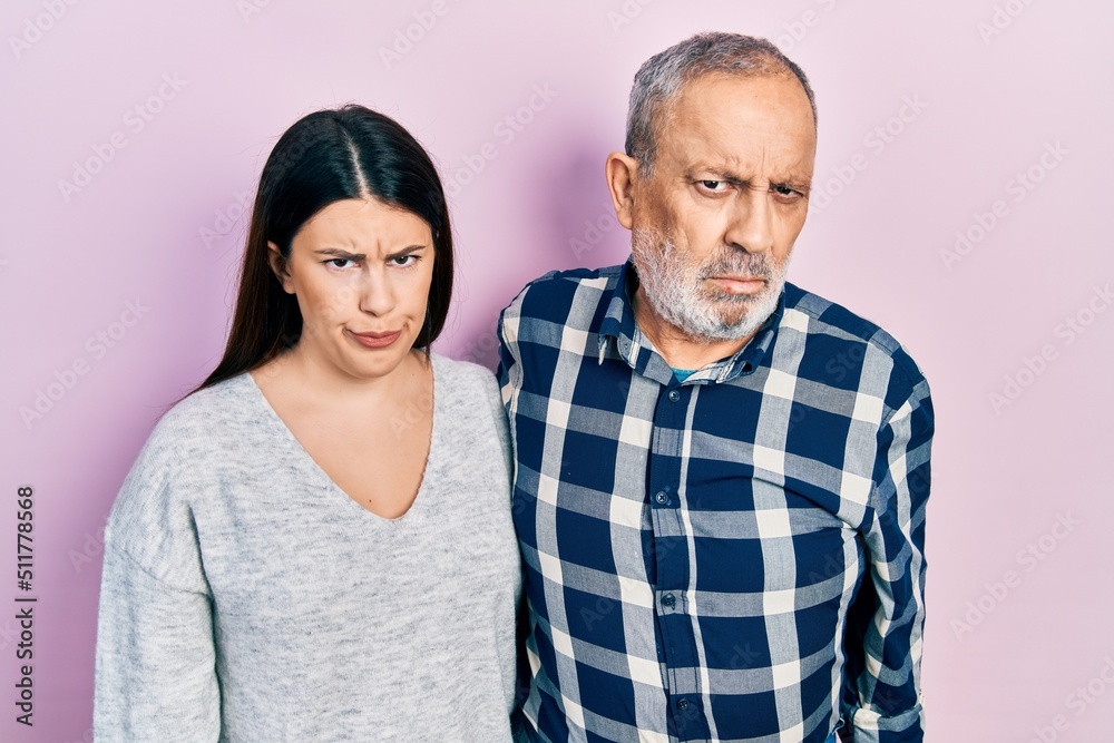 Hispanic father and daughter wearing casual clothes skeptic and nervous, frowning upset because of problem. negative person. Hispanic father and daughter wearing casual clothes skeptic and nervous, frowning upset because of problem. negative person.