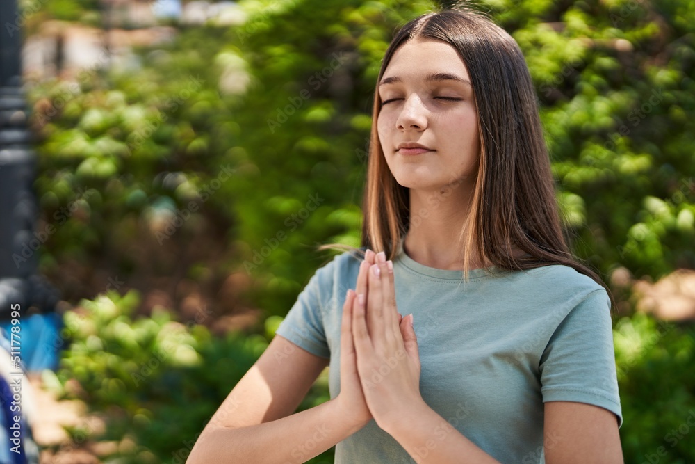 Adorable girl praying at park Adorable girl praying at park