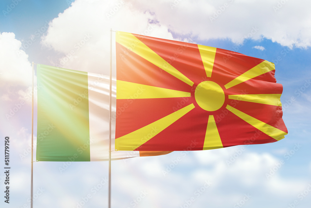 Sunny blue sky and flags of north macedonia and ireland