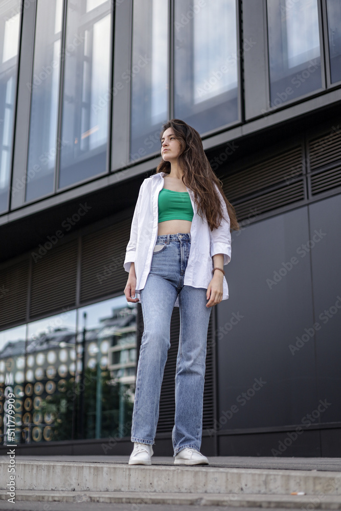 A girl in casual clothes walks in the city center. Beautiful life.