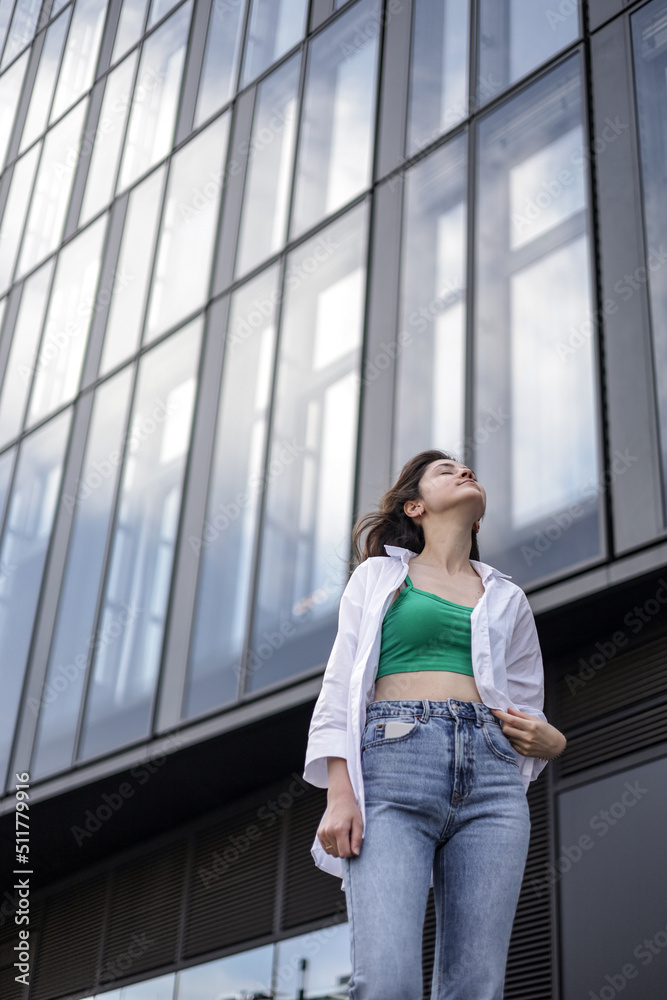 A girl in casual clothes walks in the city center. Beautiful life.