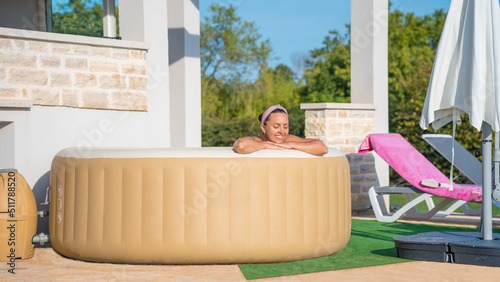 Foto Girl in an inflatable jacuzzi in front of the house.
