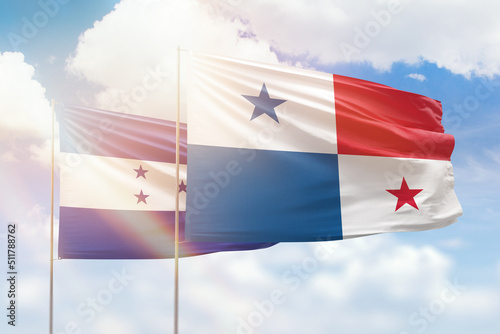 Sunny blue sky and flags of panama and honduras