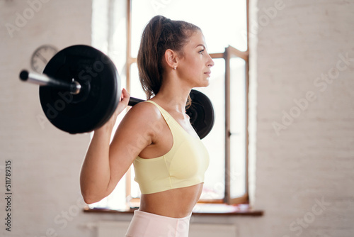 A young woman actively trains in a fitness club, uses sports equipment, does aerobics and Pilates