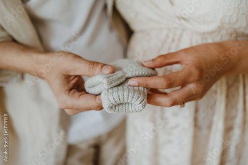 Tableau sur toile Mains de parents tenant des chaussettes de bébé nouveau né dans une chambre d'en
