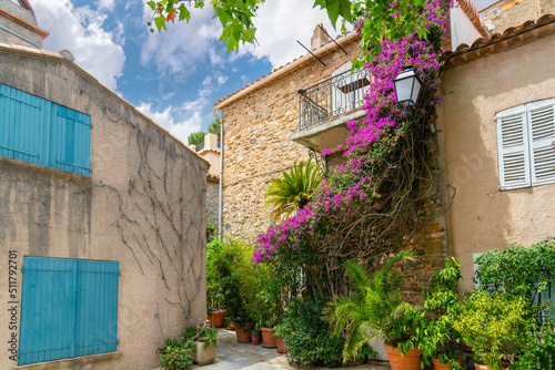 Colorful purple bougainvillea flowers line the narrow streets of the Old Town area of the medieval village of Grimaud, France, in the hills above Saint-Tropez on the Cote d'Azur. © Kirk Fisher
