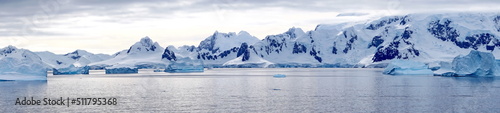 Panorama of icebergs floating in the bay, in front of snow covered moutains at Portal Point in Antarctica © Angela