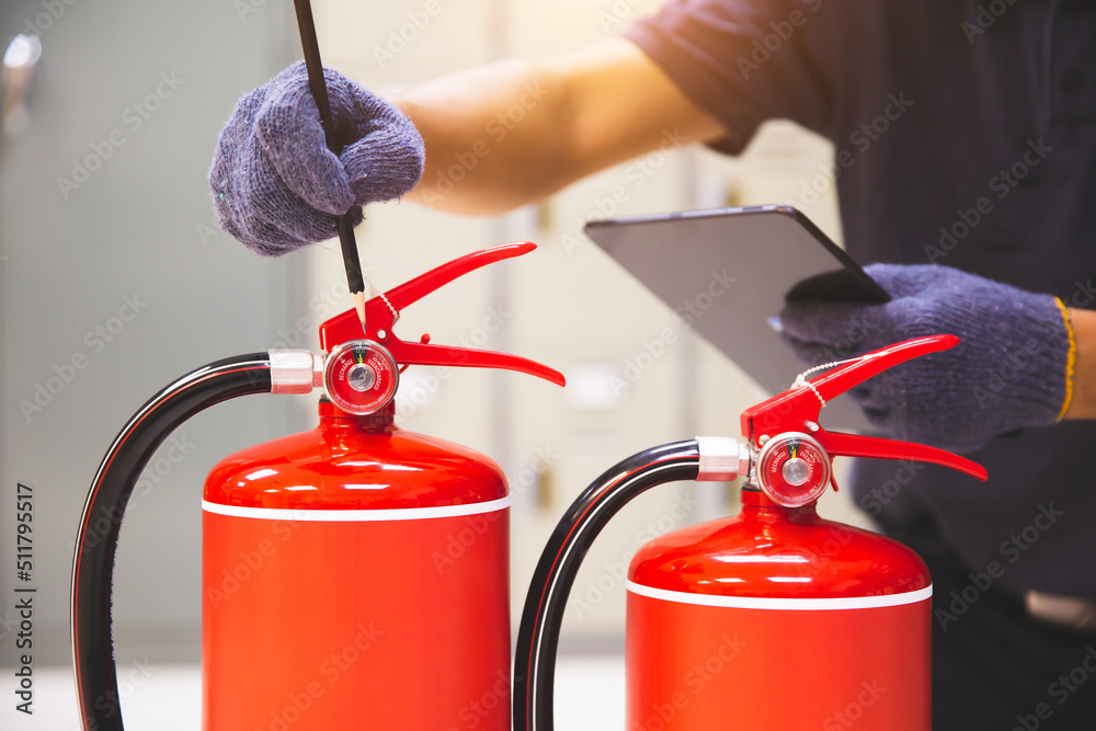 Fire extinguisher has hand engineer inspection checking pressure gauges to prepare fire equipment for protection and prevent emergency case and safety or rescue and alarm system training concept. Fire extinguisher has hand engineer inspection checking pressure gauges to prepare fire equipment for protection and prevent emergency case and safety or rescue and alarm system training concept.
