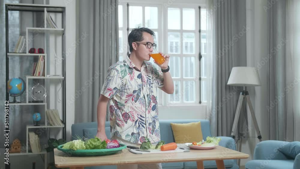 Smiling Asian Man Enjoys Drinking Orange Juice While Preparing Healthy Food At Home
Smiling Asian Man Enjoys Drinking Orange Juice While Preparing Healthy Food At Home