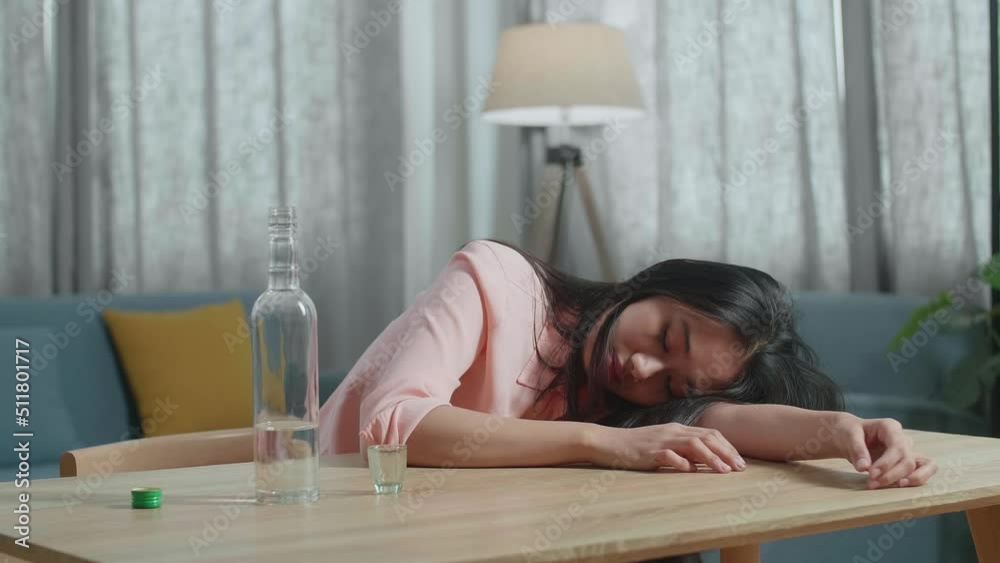 Close Up Of Drunk, Depressed Asian Woman Drinking Vodka From Glass During Using Smartphone At Home
