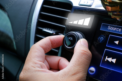 Obraz na płótnie Driver hand adjust volume control on the car radio dashboard