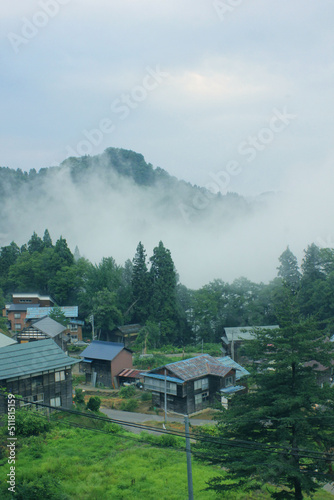 日本の田舎の風景 朝霧に包まれる山間の民家