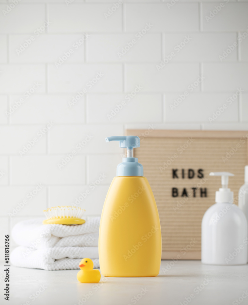 An empty bottle of baby soap and shampoo next to accessories in the bathroom. Template for design An empty bottle of baby soap and shampoo next to accessories in the bathroom. Template for design