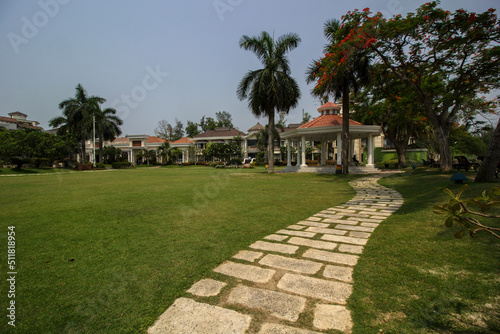 Beautiful lawn with sitting area and decorated pavement at bright day light with selective focus. © Rima