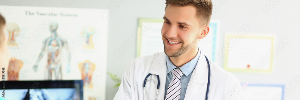 Smiling male doctor shaking hands with a medical professional Smiling male doctor shaking hands with a medical professional