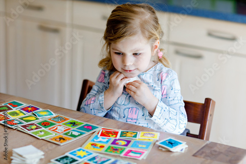 Foto Excited smiling cute toddler girl playing picture card game